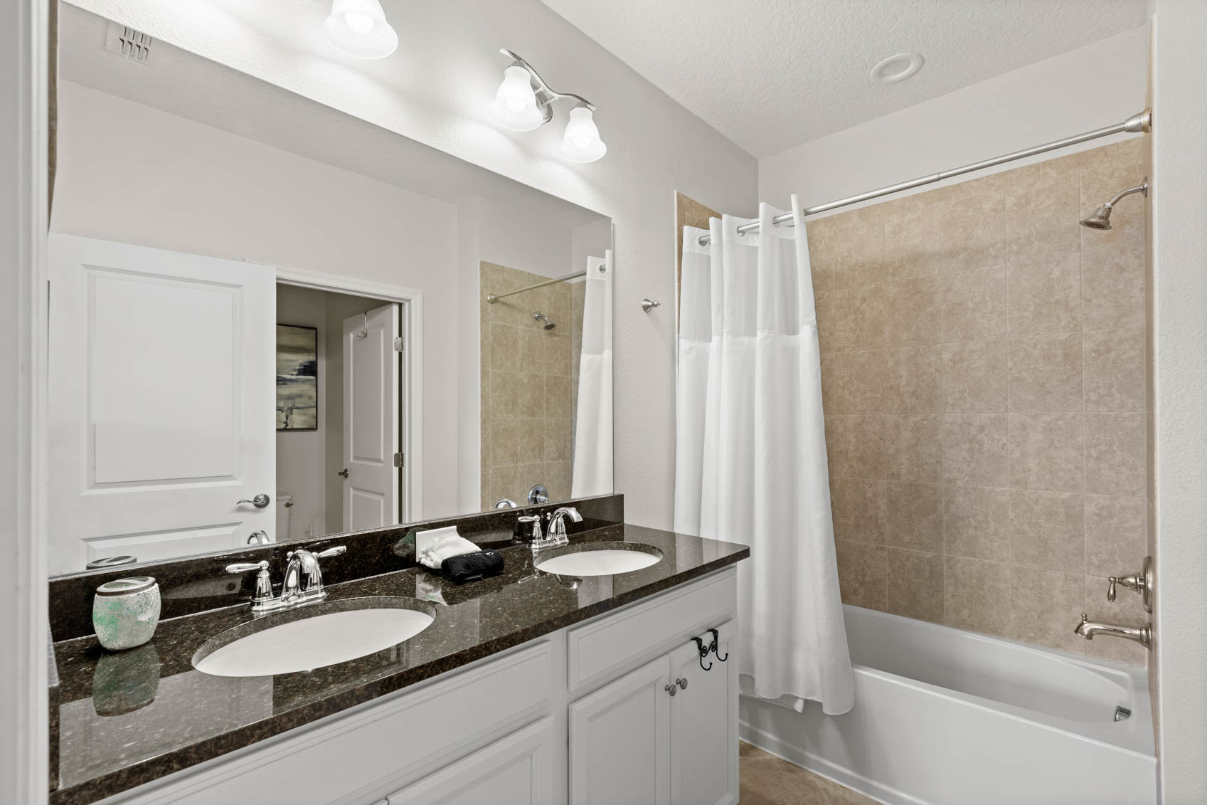 primary bathroom with dark counter and double sinks
